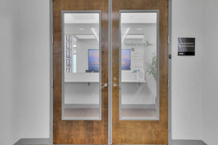 Entrance doors to a TwelveStone Health clinic with the reception area visible inside.