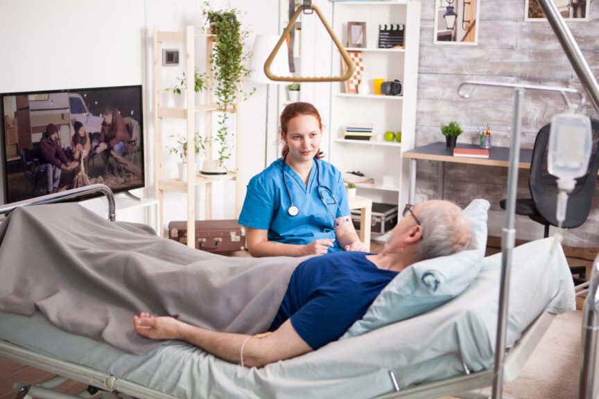 Healthcare professional providing enteral nutrition and home infusion support to a patient at home.