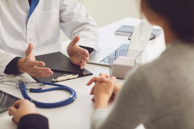 Doctor discussing iron infusion treatment options with a patient during a medical consultation.